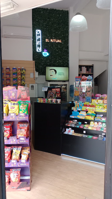 Entrada de Kiosco El Ritual, con cartel OPEN de neón y pared verde